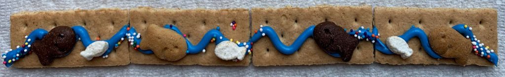 Graham crackers with icing swirls to make water, sprinkles and S'mores goldfish snacks