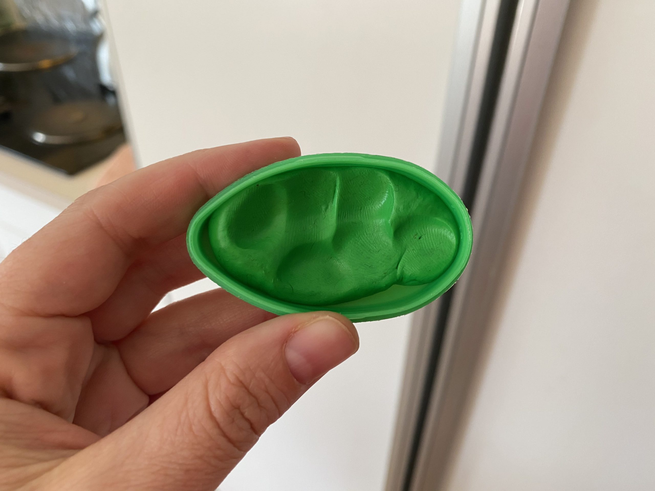 Hand holding green Silly Putty