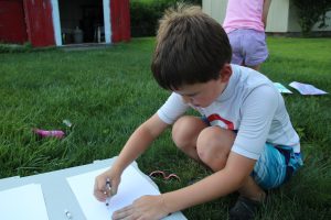A child drawing on a blank piece of paper