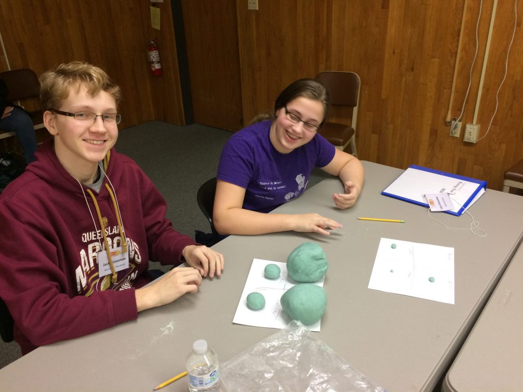 Two students make play dough planets 
